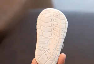 Macro detail view showing anti-slip texture of white soft sole for toddler shoes