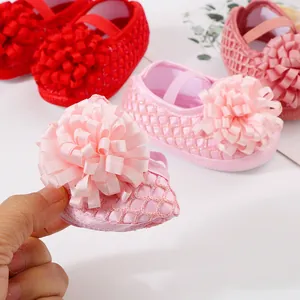 Vue détaillée d'une chaussure de princesse pour bébé rose avec semelle souple et fleur.