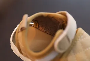 Detail view of soft beige baby walking sandals with breathable mesh lining and padded heel