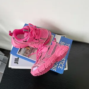 Detailed view of vibrant pink mesh toddler sneakers placed on magazines with soft sole.