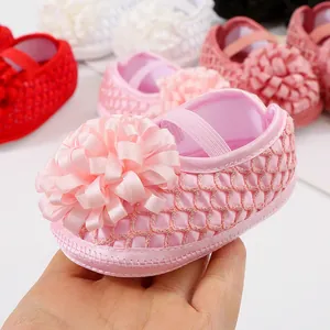 Gros plan d'une chaussure de marche princesse rose pour bébé avec fleur en ruban