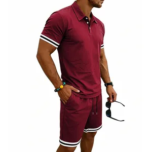 Vista laterale di un set polo bordeaux da uomo con polsini a righe e pantaloncini coordinati.