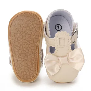 Dettaglio scarpe primi passi bambina con fiocco beige e suola in gomma antiscivolo