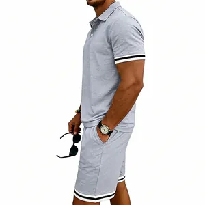 Vista laterale di un completo polo e shorts grigio uomo con rifiniture a righe sport.