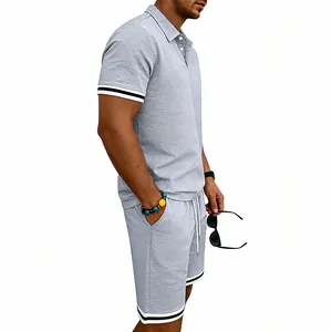 Vista laterale completo uomo polo e pantaloncini grigi con dettagli a righe