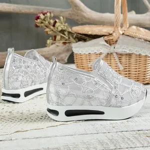 Detailansicht silberner Pailletten-Mesh-Sneaker mit dicker weißer Plateausohle.