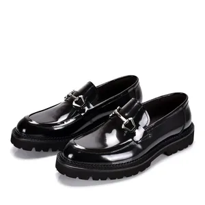 Detailansicht glänzender schwarzer Leder-Loafer mit Metallspange und dicker Profilsohle