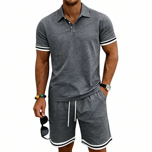 Dettaglio del set polo e pantaloncini da uomo grigi con finiture a righe bianche
