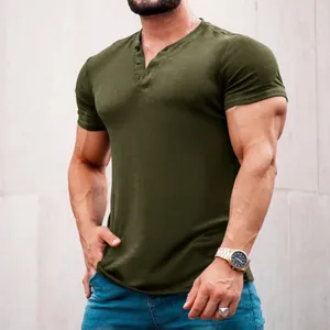 Close-up detail of a muscular man wearing an olive green short sleeve Henley shirt