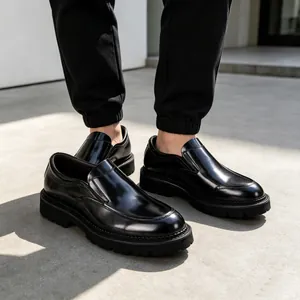 Gedetailleerd overzicht van glanzende zwarte lakleren loafers voor heren met dikke profielzool.