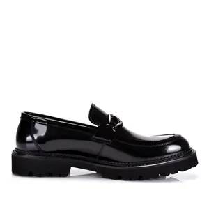 Detaillierte Profilansicht eines schwarzen Lackleder-Loafers mit einer markanten Profilsohle.