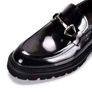 Nahaufnahme von schwarzen Lackleder-Loafers mit silberner Trense und Profilsohle