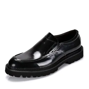 Detailweergave van de glanzende zwarte laklederen afwerking van herenloafers met dikke zool