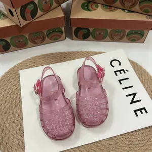 Rosa glitzernde gewebte Jelly-Sandalen für Kinder auf minimalistischem Display