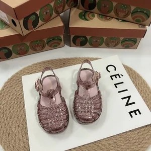 Detailansicht von glitzernden Kinder-Jelly-Sandalen in Roségold mit Webmuster.