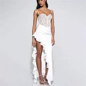 Full view of white lace camisole maxi dress featuring sexy high slit and ruffle hemline