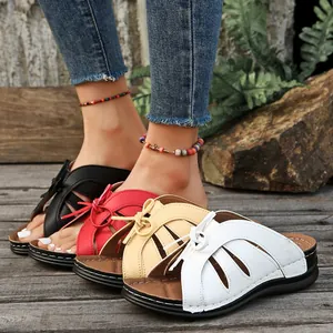 Vista detallada de las sandalias de cuña para mujer con lazo en negro rojo amarillo blanco.