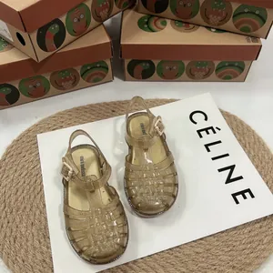 Detailansicht von golden glitzernden geflochtenen Jelly-Sandalen für Kinder mit Lochmuster