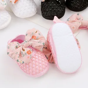 Nahaufnahme rosa Babyschuhe mit floraler Schleife und rutschfester weicher Sohle