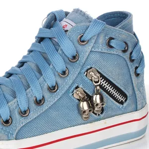 Close-up of light blue denim high-top canvas shoe with zipper and metal skull charms.