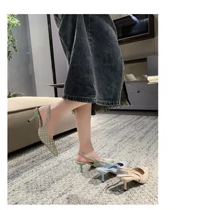 Close-up of French-style pointed-toe slingback sandals in multiple plaid patterns