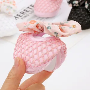 Nahaufnahme der Flexibilität und der weichen Sohle des rosa Babyschuhs mit Schleife