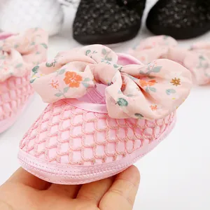 Nahaufnahme rosa Babyschuhe mit großer Blumenschleife und atmungsaktivem Mesh-Obermaterial.