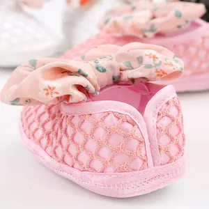 Hochwertige Detailaufnahme von rosa Baby-Lauflernschuhen mit einer hübschen Blumenschleife