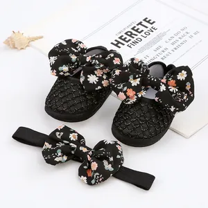 Detailansicht von niedlichen Baby-Prinzessin-Schuhen mit Blumenschleife und Stirnband
