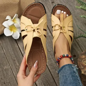 Vista detallada de sandalias de cuña beige para mujer con lazo decorativo y aberturas