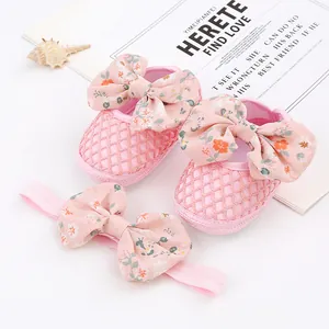 Nahaufnahme von rosa Baby-Prinzessin-Schuhen mit passendem Blumen-Stirnband