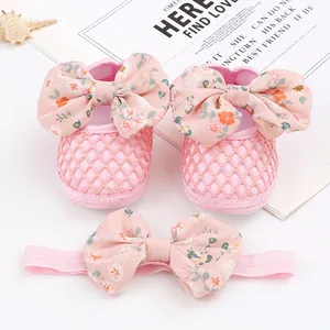 Süßes Set aus rosa Baby-Prinzessinnenschuhen und passendem geblümten Stirnband.