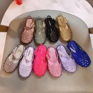 Variopinti sandali intrecciati in gomma glitterata per bambini in tonalità vivaci.