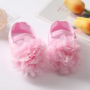 Dettaglio di scarpe da principessa rosa per neonata con un grande fiore in chiffon