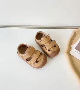 Vue de dessus de sandales pour bébés en cuir marron avec semelles souples et velcro