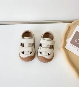 Vue détaillée de sandales en cuir beige pour bébé avec double velcro sur fond blanc