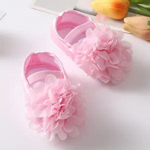 Dettaglio di scarpine da principessa rosa per neonata con grande fiore e suola in morbido raso