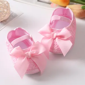 Nahaufnahme von rosa Baby-Prinzessinenschuhen mit großer Schleife und feiner Spitze