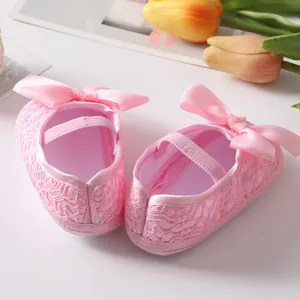 Detailansicht von rosa Spitzen-Babyschuhen mit niedlicher Schleife und Gummiband