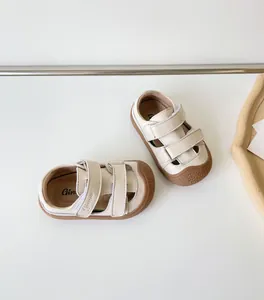 Détail de sandales bébé en cuir crème avec semelles en caoutchouc souple et velcro