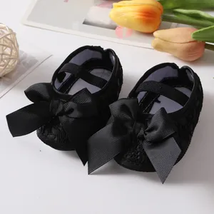 Detailansicht der schwarzen Baby-Prinzessin-Schuhe mit eleganter Spitze und einer großen Schleife