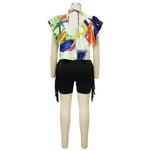 Rückendetail eines abstrakten Print-Tops mit Reißverschluss und schwarzen Fransen-Shorts