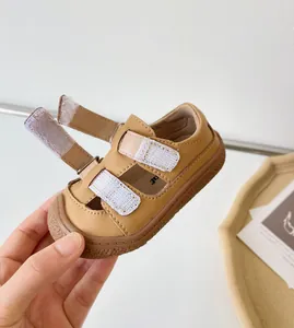 Gros plan de sandales en cuir véritable pour bébé avec brides velcro réglables