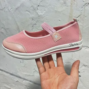 Detail view of pink mesh Mary Jane flat shoes with star strap and white wedge sole.