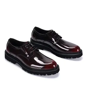 Close-up detail of burgundy patent leather men's Derby shoes with thick black lug soles