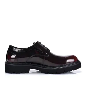 Side profile detail view of men's burgundy patent leather Derby shoe with a thick lug sole