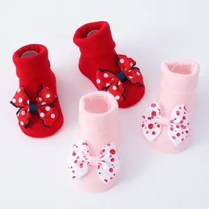 Detalle de calcetines para recién nacidos rojos y rosas con grandes lazos a lunares