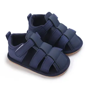 Sandalias de verano azul marino para bebés varones vistas desde un ángulo con suelas