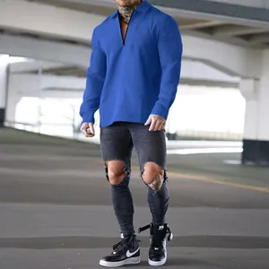 Nahaufnahme des blauen Waffelstrick-Langarm-Poloshirts für Herren im urbanen Umfeld