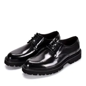 Close-up of black patent leather Derby shoes with thick soles and classic laces.